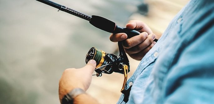 man holding the best trout spinning reel
